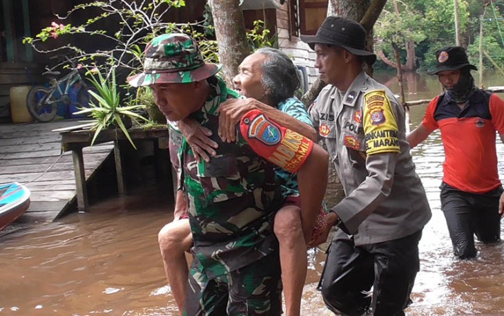 Anggota TNI dan Polri saat bantu lansia terdampak banjir untuk dapat pelayanan kesehatan.