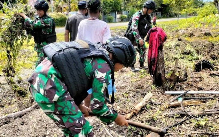  Satgas Yonif Raider 142/KJ saat Bantu Warga Bersihkan Kebun