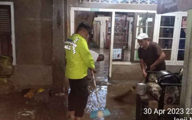 Bhabinkamtibmas Polsek Batang Angkola, Bripka Tommy Harianto, SH, tampak hadir menolong saat Rumah warga terendam banjir lebih kurang 30 Cm, pada Minggu (30/4/2023) malam