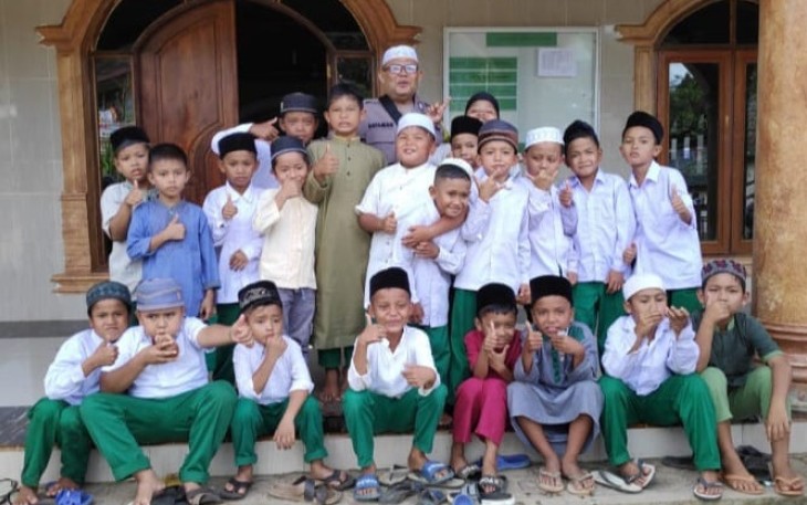Bhabinkamtibmas Polsek Batang Toru, Aiptu Sayaman Siregar, berikan motivasi ke siswa Madrasah Diniyah agar cepat bisa baca tulis Al Quran, Kamis (3/8/2023) sore.