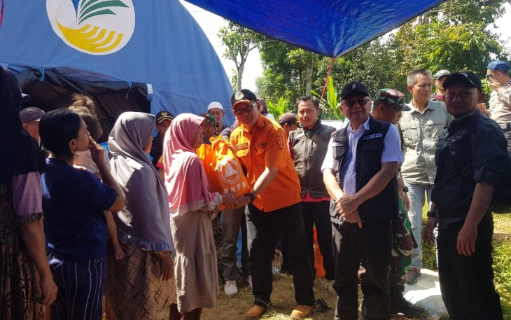 Wakil Bupati Sukabumi Iyos Somantri (baju putih rompi hitam) dan Sekretaris BPBD Kabupaten Sukabumi Yudistira (baju orange) menyerahkan bantuan sembako kepada warga terdampak gempa di Kabupaten Sukabumi, Jawa Barat pada Kamis (14/12)