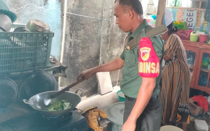 Babinsa Jajaran Kodim 1310/Bitung saat membantu warga menyiapkan makanan