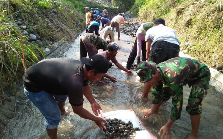 Babinsa Koramil Dagangan Bantu Warga Bersihkan Saluran Irigasi