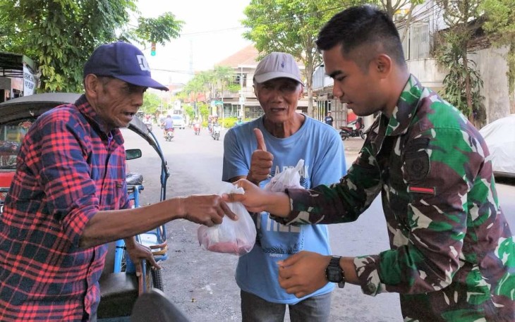 Prajurit Menarmed 2 Kostrad saat membagikan paket daging qurban 