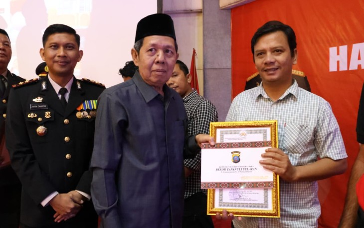 Wartawan/Kabiro Tabagsel Klikwarta.com Bambang Ginting saat menerima Piagam Penghargaan Atas Kinerja Yang Baik Dalam Amplikasi Berita Positif Polri, dari Kapolres Tapsel AKBP Imam Zamroni yang diserahkan langsung perwakilan dari salah satu Forkopimda