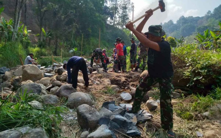 Pecahkan batu bangun pondasi jembatan di lokasi TMMD Kodim Madiun 
