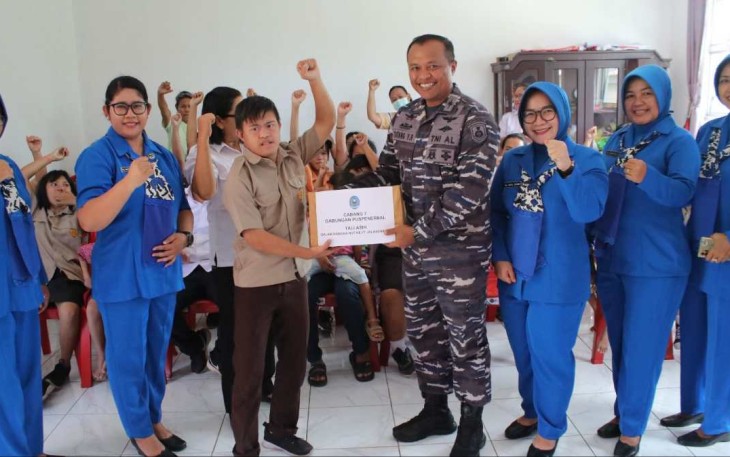 Danlanudal Manado Letkol Laut (P) Tatang Yanuar Ristanto saat memberikan bingkisan, Kamis (24/8) 