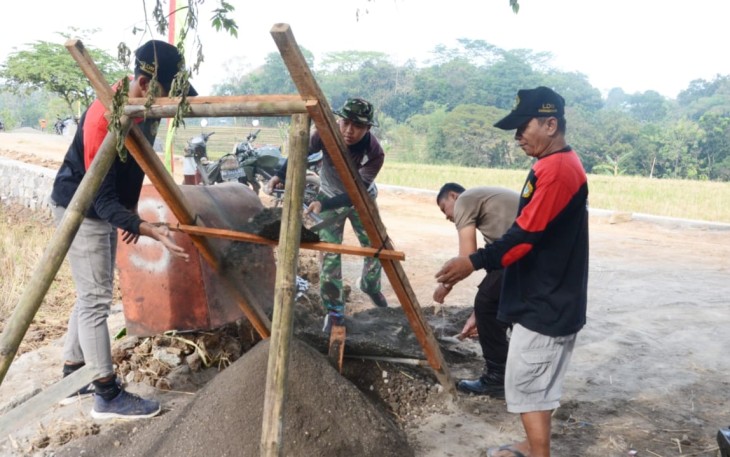 "Tampak anggota satgas TMMD Reg ke-117 Kodim Karanganyar, bersama dengan wargasedang mengayak pasir"