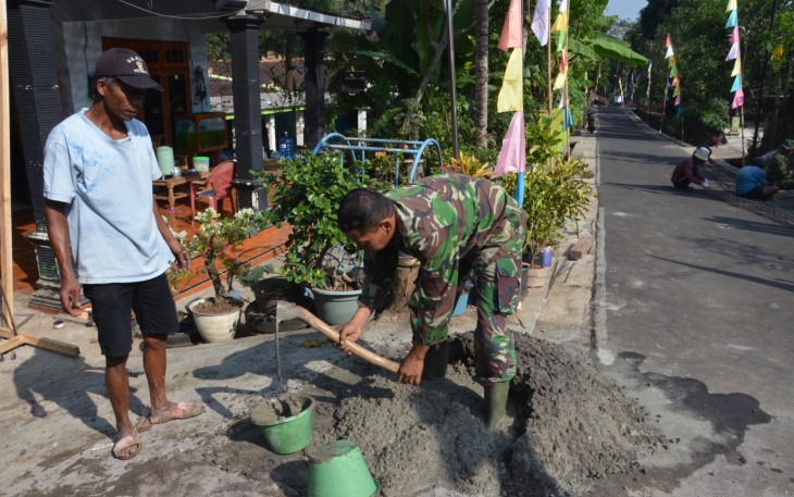 "Satgas TMMD Reg ke-117 desa Gentungan sedang mengaduk semen dan pasir"
