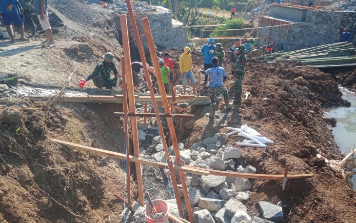 "Satgas TMMD Reg Mojogedang bersama warga sedang mengerjakan pekerjaan talud jalan"