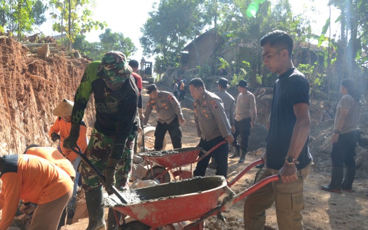 "Anggota Satgas TMMD Reg desa Gentungan tampak sedang mendorong arco/angkong"
