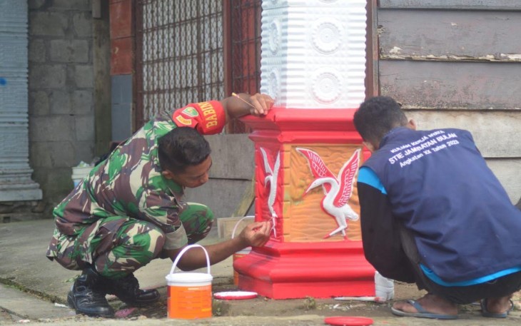  Babinsa Koramil 1710-02/Timika saat Cat Gapura di Kampung Mawokau Jaya