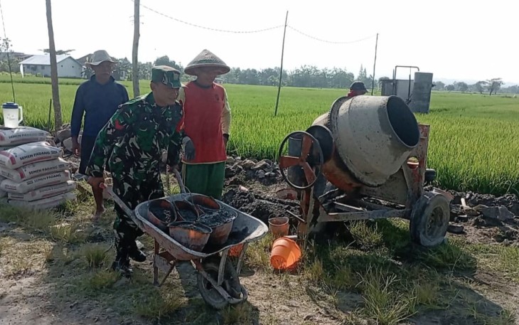 Babinsa Kodim Madiun saat Bantu Masyarakat Bangun Saluran Irigasi