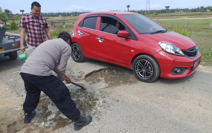 Kapolsek Nurussalam IPTU Mulyadi,SH.MH,bersama anggotanya dibantu masyarakat Desa Setempat melakukan penambalan jalan berlubang yang dianggap membahayakan para pengendara saat melintas