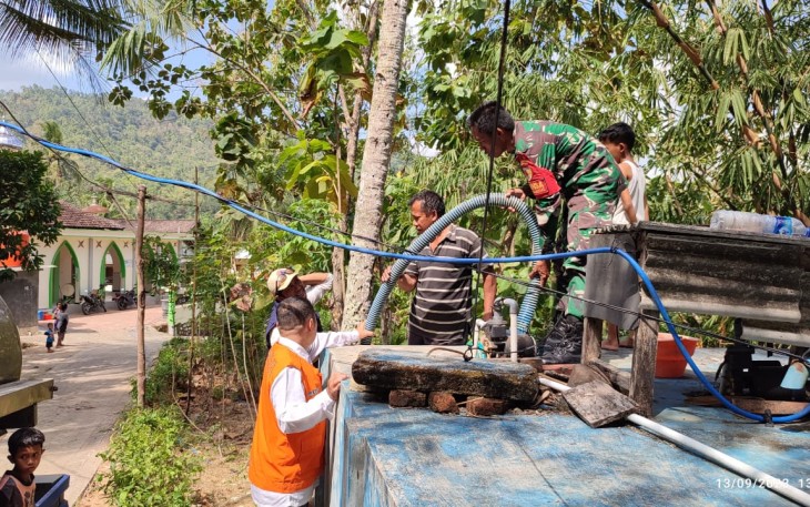 Babinsa Koramil 0806/11 Panggul saat mendistribusikan bantuan air bersih kepada warga yang terdampak kekeringan, khususnya di Desa Ngrencak, Kecamatan Panggul, Kamis (14/9/2023).