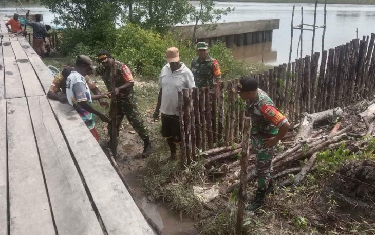 Babinsa Koramil Kokonao bersama Warga saat Perbaiki Tanggul
