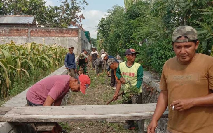 Sertu Aris saat ikut Kerja Bakti Bersihkan Saluran Air