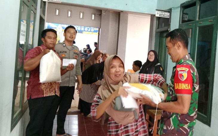 Babinsa Koramil 0801/11 Donorojo saat Dampingi Penyaluran Beras