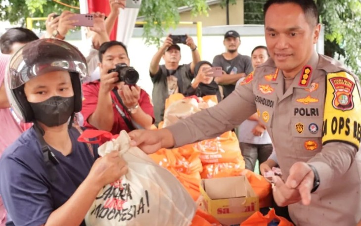 Kapolres Metro Jakarta Barat Kombes Pol M Syahduddi saat melayani warga membeli paket sembako murah di Mapolres, Rabu (28/2)