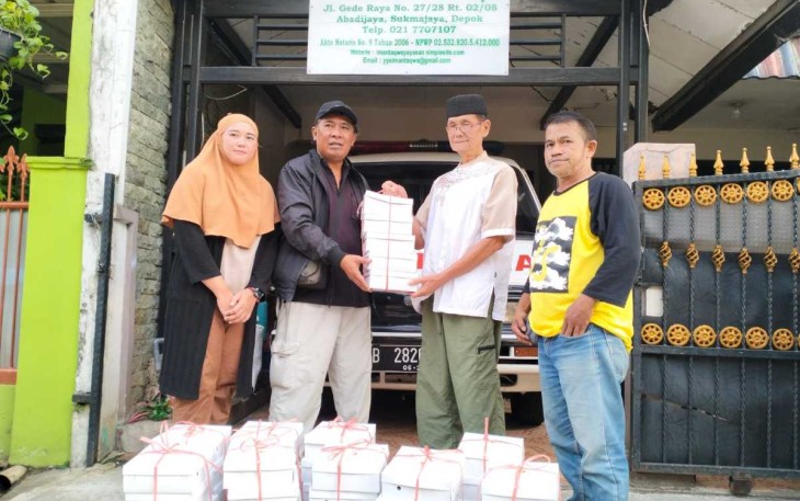 Ketua Komunitas Jurnalis Depok Jhon Anis saat menerima nasi box dari Yayasan Iman Taqwa, Depok, Selasa (12/3)