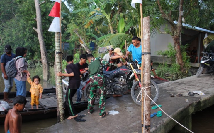Bantu Warga Menyebrang Dari Tangkahan