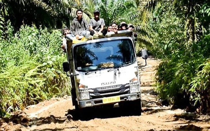 Antusias warga bersama Satgas TMMD gunakan truk lintasi jalan yang sudah selesai diperkeras.
