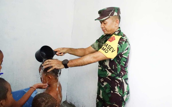 Ketua Tim Wasev TMMD ke-120 Kodim 0209/LB Kolonel Inf Parluhutan Marpaung saat memandikan anak-anak desa Selat Beting dengan air bersih sumur bor program unggulan Kasad. Jum'at (31/5)