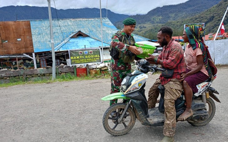 Prajurit Satgas Pamtas RI-PNG Mobile Yonif 323/BP Kostrad Pos Kout Ilaga Menyalurkan Cinta Kasih nya di kegiatan Minggu Kasih dengan membagikan Nasi Bungkus Kepada Masyarakat yang lewat Depan Pos, Distrik Ilaga, Kab.Puncak, Minggu (10/03/2024)
