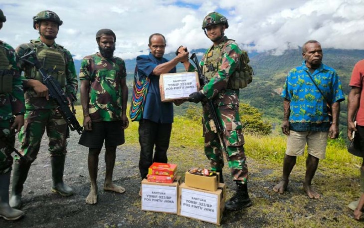 Satgas Pamtas Mobile RI-PNG Yonif 323/Buaya Putih Kostrad Pimpinan Lettu Inf Arif Agung Caroko memberikan bantuan kepada saudara pedalaman papua di Kampung Wombru, Distrik Mege'abume, Kab Puncak, Papua, Jumat (08/03/2024).