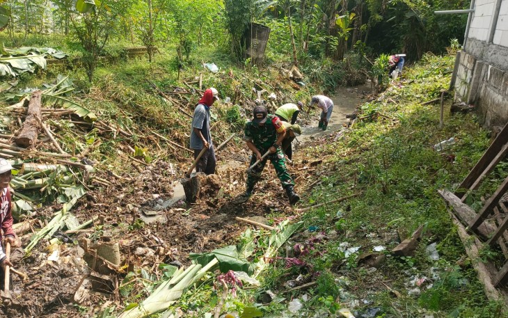 Babinsa Koramil Pilangkenceng Laksanakan Kerja Bakti Pembersihan Saluran Air