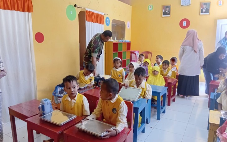 Babinsa saat mengawal pembagian makanan bergizi di salah satu TK