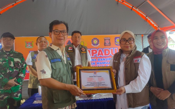 Penyerahan bantuan secara simbolis oleh Direktur Mitigasi Bencana Berton Suar Panjaitan kepada Bupati Mamuju Siti Sutinah Suhardi di Pos Komando Terpadu Penanganan Darurat Banjir dan Longsor Kabupaten Mamuju, Sulawesi Barat, Rabu (29/1)