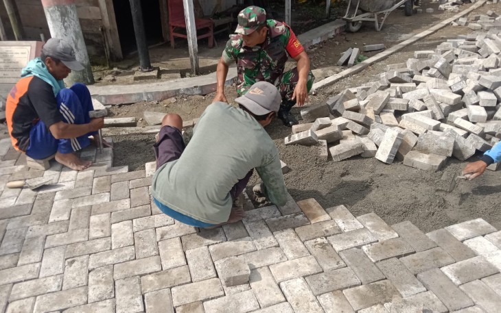 Babinsa Koramil Kedunggalar Bantu Warga Pasang Paving