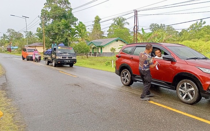 Babinsa Koramil 1710-07/Mapurujaya saat Bagikan Bendera Merah Putih Kepada Pengguna Jalan