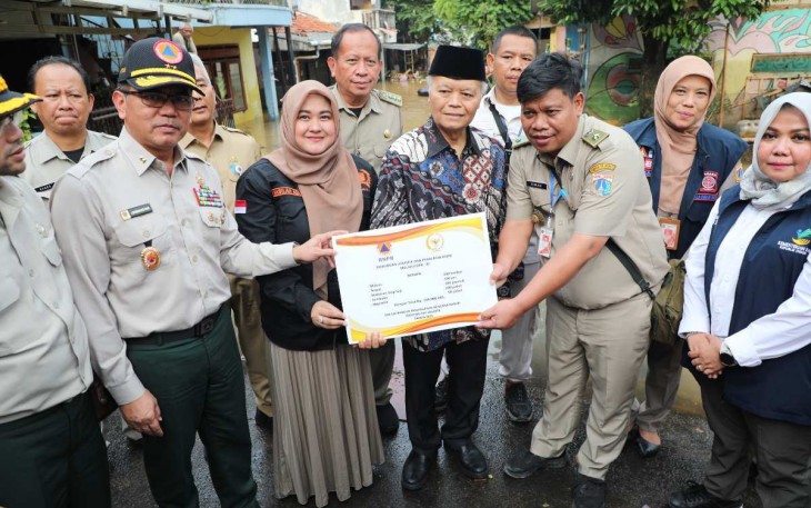 Deputi Bidang Penanganan Darurat BNPB Mayjen TNI Lukmansyah (topi hitam) bersama Wakil Ketua Majelis Permusyawarahan Rakyat (MPR) Republik Indonesia / Anggota Komisi VIII Dewan Perwakilan Rakyat (DPR) Republik Indonesia Hidayat Nur Wahid (kopiah hitam) saat meninjau dan memberikan simbolis bantuan kepada warga terdampak banjir di Kelurahan Rawajati, Kecamatan Pancoran, Jakarta Selatan, Jakarta pada Senin (3/3) sore hari.