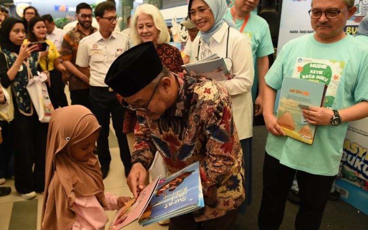 Mendikdasmen Abdul Mu'ti saat memberikan buku bacaan di stasiun Pasar Senen, Jakarta, Rabu (26/3)