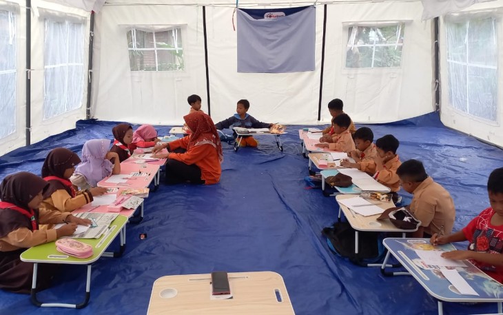 Para siswa belaja di tenda ruang kelas darurat.
