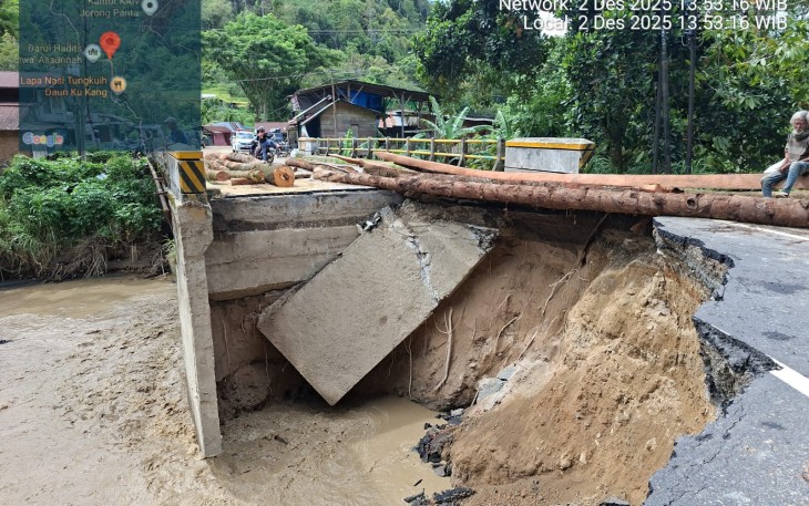 Perbaikan darurat infrastruktur jembatan yang putus diterjang banjir di Kabupaten Agam, Rabu (3/12). Perbaikan darurat dilakukan dengan balok pohon kelapa sehingga akses jalan dapat dilalui paling tidak dengan kendaraan roda dua.