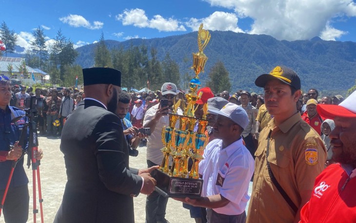 Penyerahan piala dilakukan secara meriah di tengah lapangan upacara, disaksikan oleh ribuan warga yang hadir.