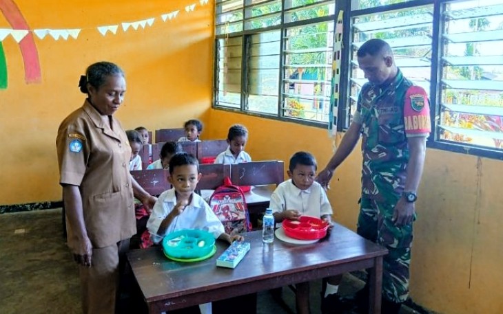 Babinsa Koramil 1708-01/Biak Kota, Posramil 01 Biak Timur mendampingi pendistribusian makanan bergizi gratis untuk anak-anak sekolah di Distrik Biak Timur, Kabupaten Biak Numfor, Selasa (15/4/2025)