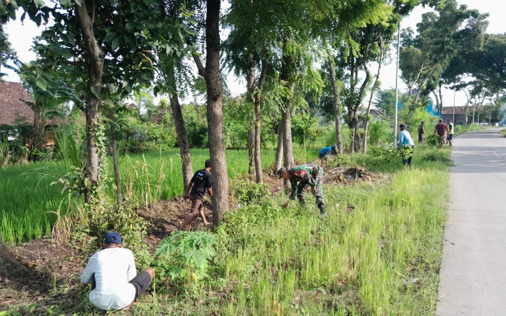 Babinsa Koramil 0803/10 Pilangkenceng saat Bersama Warga Gelar Kerja Bakti Pembersihan Jalan