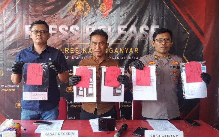 Kasat Reskrim AKP Wikan Sri Kadiyono (tengah), didampingi Kanit II Satreskrim Iptu Anjar Wardoyo dan Kasi Humas Iptu Mulyadi , menunjukkan barang bukti kasus penipuan rekrutmen BLUD RSUD Karanganyar saat konferensi pers di Mapolres Karanganyar, Kamis (30/7/2026).