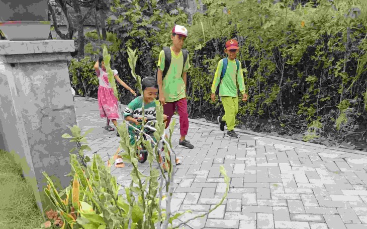 Anak-anak pulang sekolah melewati jalan paving