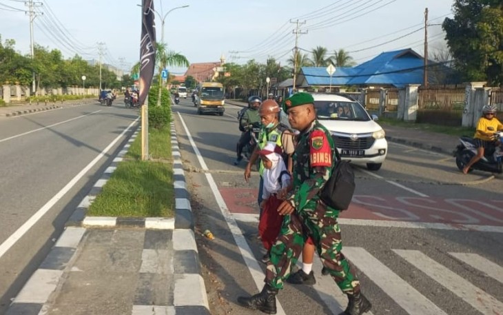 Peduli Keselamatan Anak Sekolah, Secara Rutin Babinsa Koramil Jajaran Kodim 1710/Mimika Bantu Seberangkan Jalan