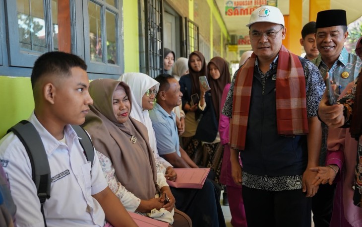 Pepi Mulyasari (berbaju abu-abu, kanan) sedang mendaftarkan putranya ke SLBN 1 Padang