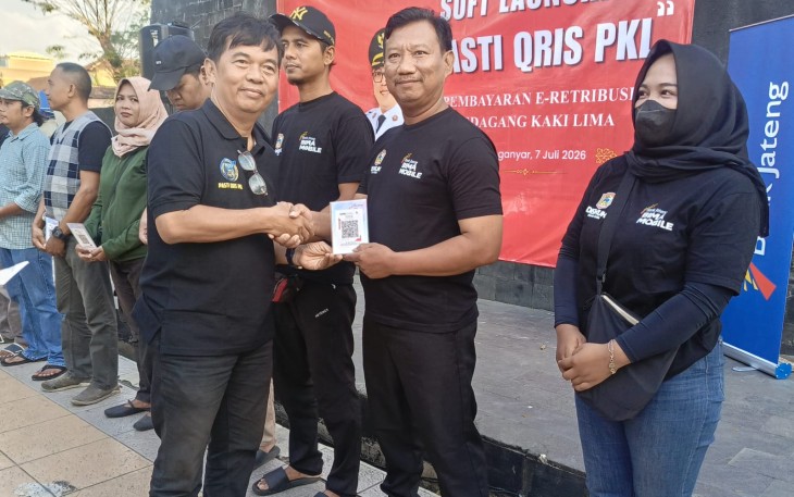 Penyerahan akrilik kode Qris secara simbolis oleh Kepala Diskuktrans ESDM Karanganyar, Sriono Budi Santoso kepada pedagang kaki lima di kawasan Taman Pancasila Karanganyar, Selasa (7/7/2026)