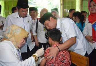 Wakil Walikota (Wawali) Bengkulu Dedy Wahyudi saat mendampingi salah satu siswa yang disuntik vaksin MR