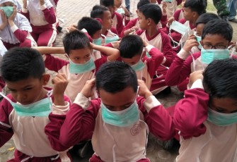 Pelajar menggunakan masker saat berolah raga pagi di lapangan Hiraq Lhokseumawe.