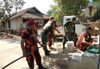 Anggota Koramil 06/Tersono bersama Pemuda Pancasila PAC Tersono saat mengecat dinding Musholla Almujahidin