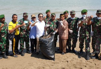 Yufrizal selaku pembina GenBI membersihkan pantai ujung blang